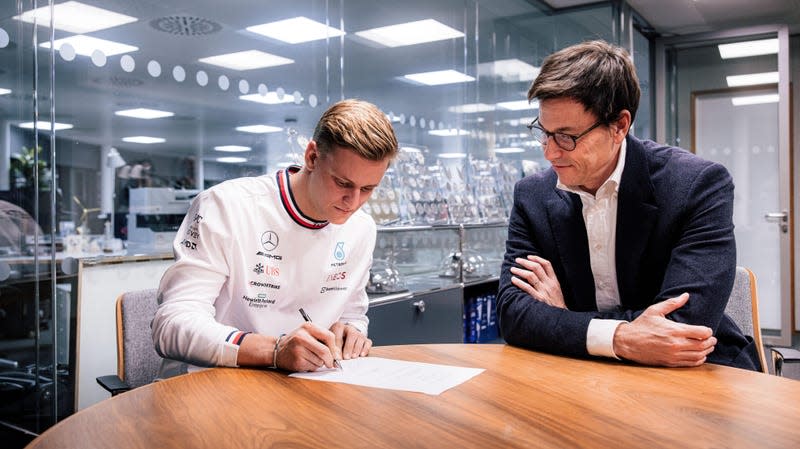 Mick Schumacher (left) signs his new contract alongside Team Principal Toto Wolff (right)