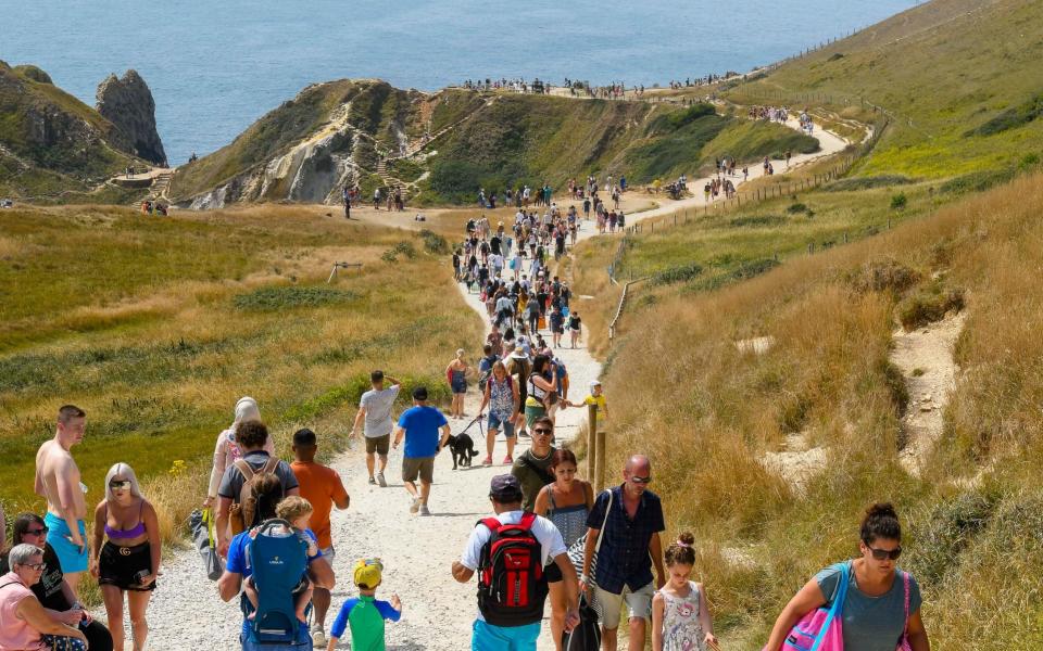 Sunbathers flocked to the beach at Durdle Door in Dorset  -  Graham Hunt/BNPS