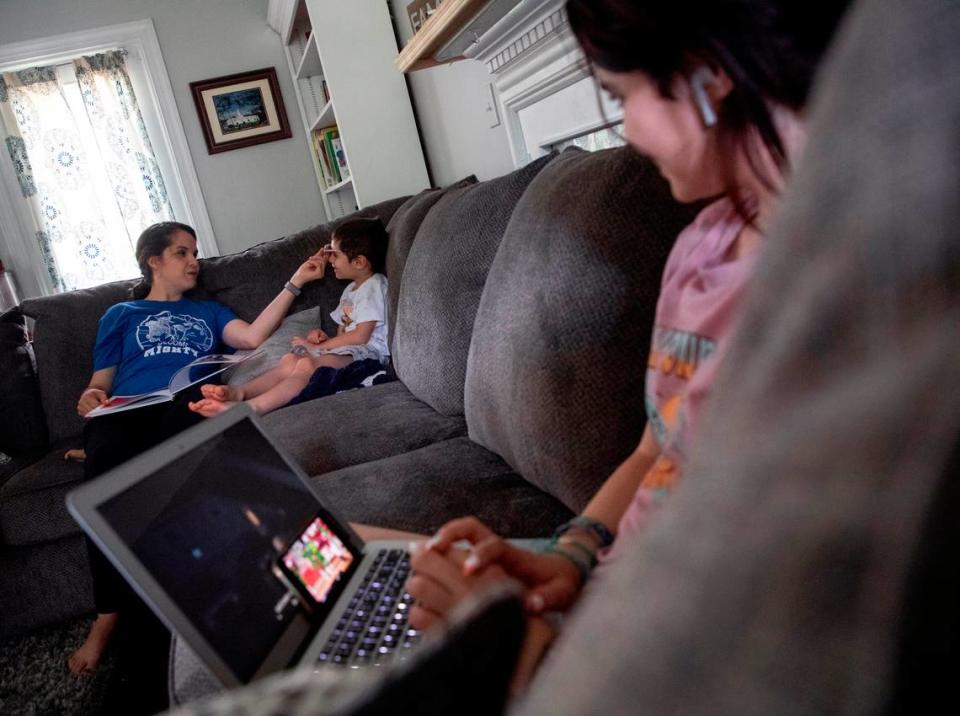 Aleesha Bake shares a laugh with her son, Preston, 5, as her daughter, Victoria, learns from home on Wednesday, May 25, 2022, in Raleigh, N.C. Bake plans to enroll her children in a charter school this fall.