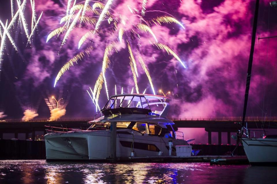 Fireworks explode in the distance behind a boat on the Manatee River in Bradenton.