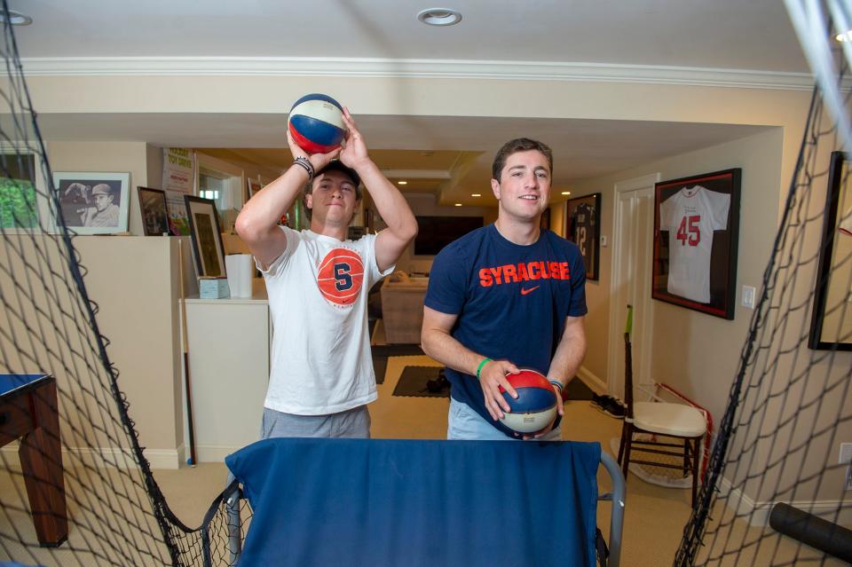 Recent Natick High School graduates Jack and Sam Shuster shoot hoops in their home basement, Aug. 22, 2022.  Both attend Syracuse University. 