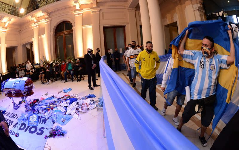 Foto del jueves de un grupo de personas pasando por delante del ataúd con el cuerpo de Diego Maradona en la Casa Rosada, en Buenos Aires