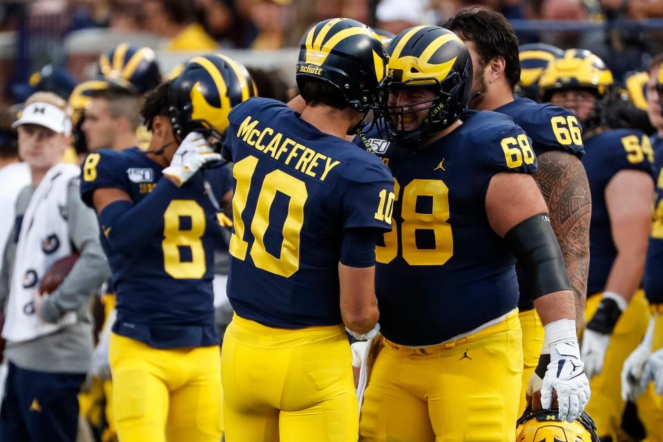 Michigan quarterback Dylan McCaffrey (10) and offensive lineman Andrew Vastardis (68) celebrate a play during the first half against Middle Tennessee State at Michigan Stadium in Ann Arbor, Saturday, August 31, 2019.