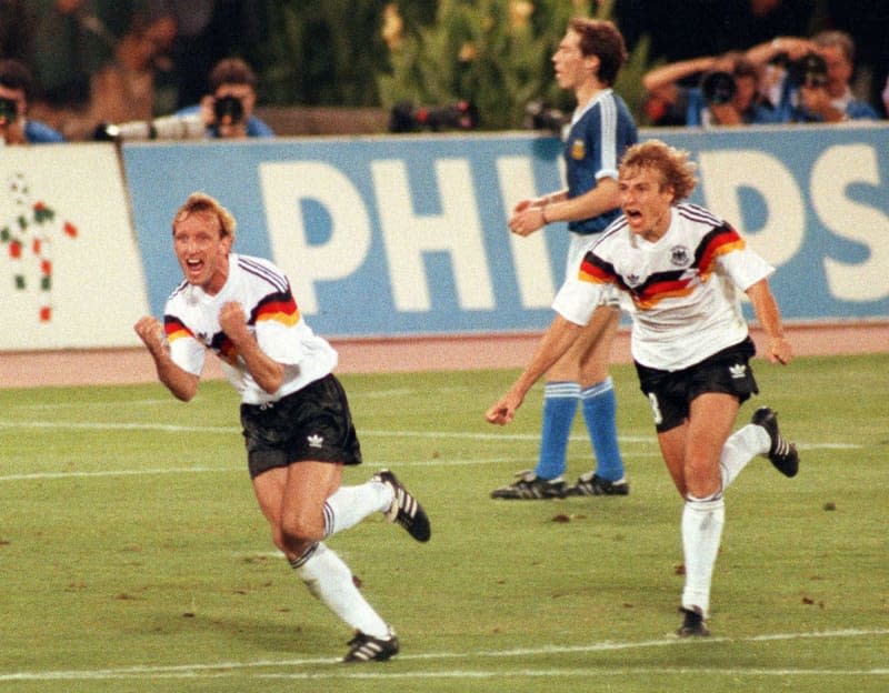 Former German international Andreas Brehme (L) and Juergen Klinsmann run across the pitch of the Olympic Stadium in Rome, celebrating after Brehme scored a penalty to give Germany a 1-0 lead. Football World Champion Andreas Brehme died at the age of 63, as his family confirmed to the German Press Agency on 20 February. Frank Kleefeldt/dpa