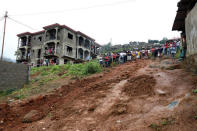 People gather in an uncompleted building near the place of the mudslide, in the mountain town of Regent, Sierra Leone. REUTERS/Afolabi Sotunde