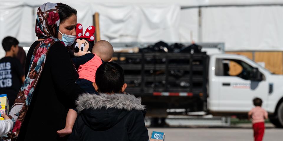 An Afghan mother and her children walk through a refugee camp in New Mexico.