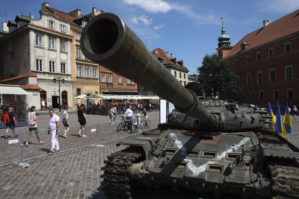 People visit an open-air exhibition of damaged and burnt-out Russian tanks and armored vehicles at the Castle Square, in Warsaw, Poland, Monday, June 27, 2022. The vehicles were captured by Ukrainian military forces during the war in the Ukraine. Ukrainian authorities announced that there are plans for similar exhibits in other European capitals such as Berlin, Paris, Madrid and Lisbon. (AP Photo/Michal Dyjuk)