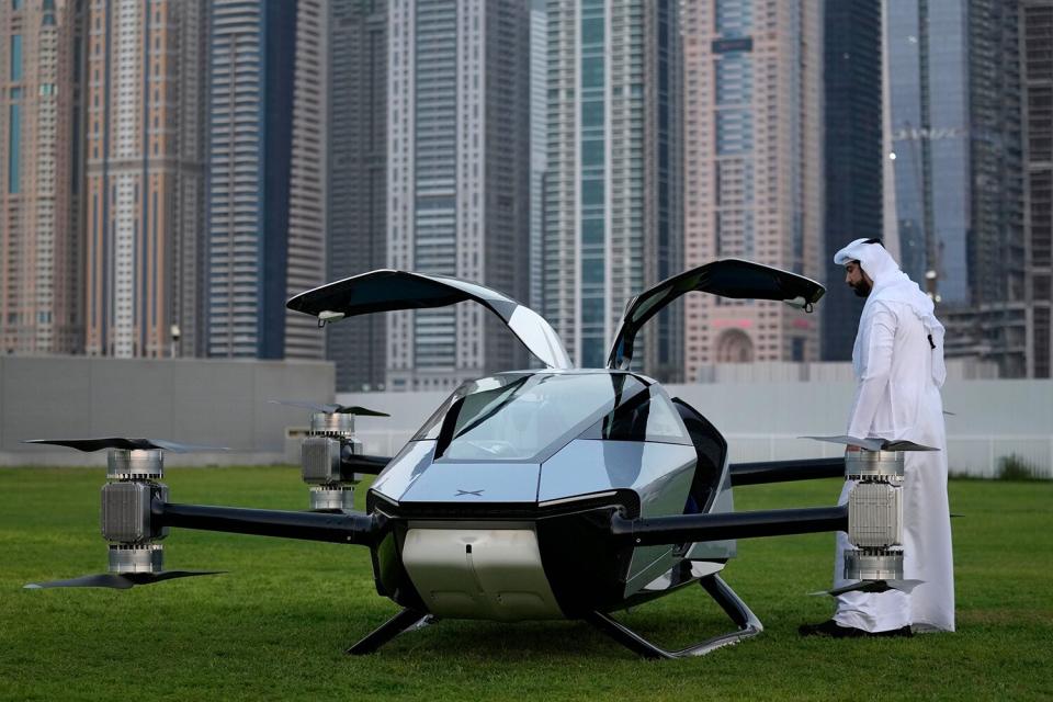 Man looks at the XPeng X2, an electric flying taxi developed by the Guangzhou-based XPeng, Inc's aviation affiliate, being tested in front of the Marina District in Dubai, United Arab Emirates