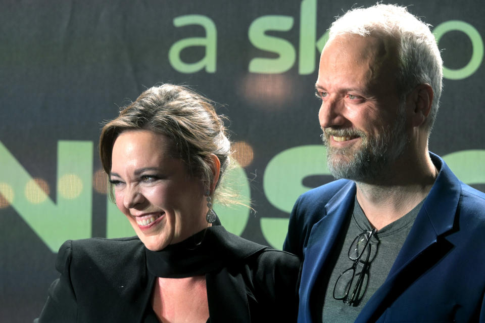 Olivia and her husband smiling and close at an event