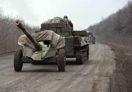 Members of the Ukrainian armed forces ride armoured personnel carriers as they pull back from Debaltseve region, near Artemivsk February 26, 2015. REUTERS/Gleb Garanich