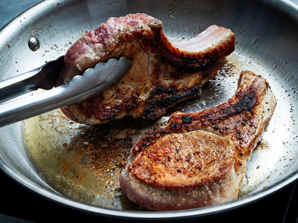 Use tongs to stand the chops on their side in the pan, fat side down, to render some of the fat (Scott Suchman/The Washington Post)