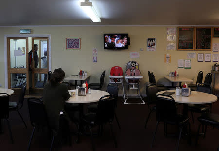 A woman watches the royal wedding of Britain's Prince Harry and Meghan Markle on TV at a restaurant in Port Stanley, Falkland Islands, May 19, 2018. REUTERS/Marcos Brindicci