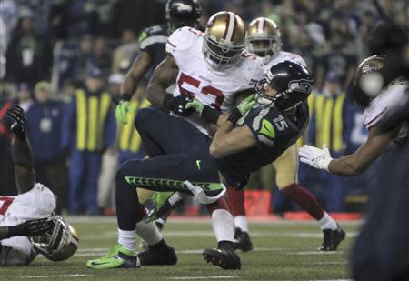 Seattle Seahawks Jermaine Kearse falls on the leg of San Francisco 49ers NaVorro Bowman injuring his knee as he loses control of the ball during the fourth quarter in the NFL's NFC Championship football game in Seattle, January 19, 2014. REUTERS/David Ryder