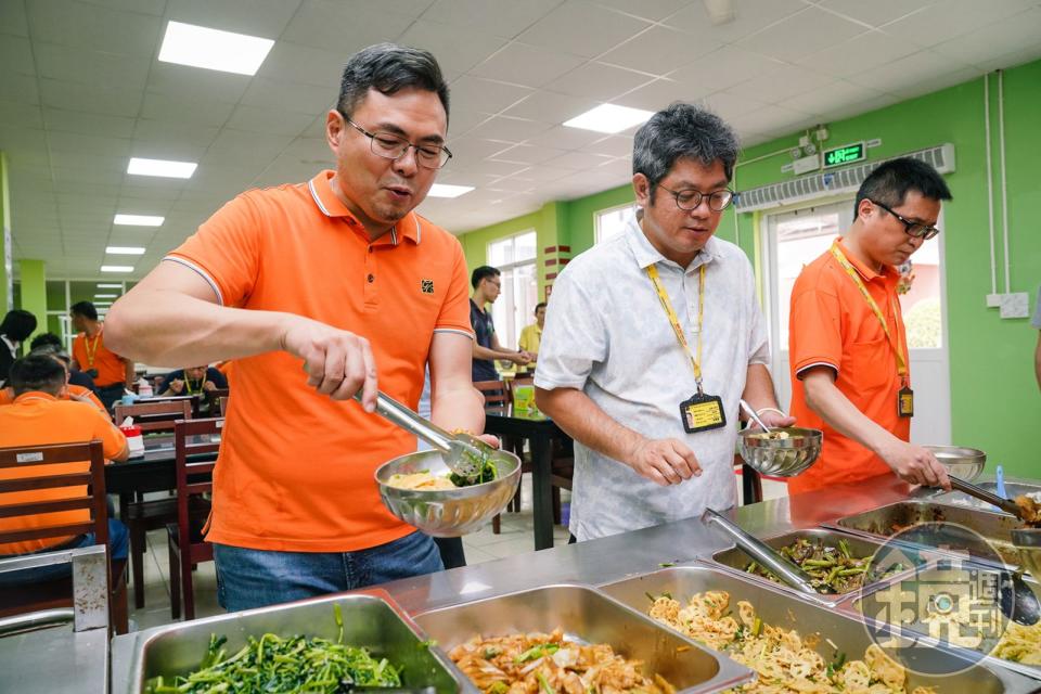 何建德（左）沒有架子，在越南廠都是在員工餐廳打菜，與幹部們一起用餐。