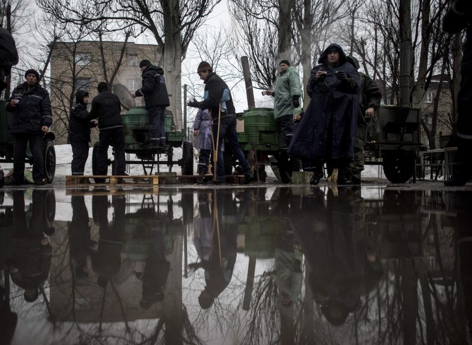 Ukrainian servicemen give free food to local residents at the humanitarian aid center in Avdiivka, Ukraine, Saturday, Feb. 4, 2017. Fighting in eastern Ukraine sharply escalated this week. Ukraine's military said several soldiers were killed over the past day in shelling in eastern Ukraine, where fighting has escalated over the past week. (AP Photo/Evgeniy Maloletka)
