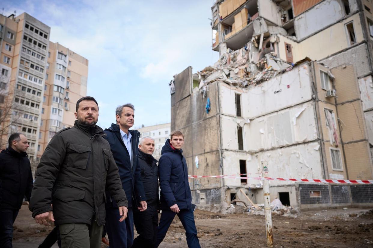 Ukrainian President Volodymyr Zelenskyy, second from left, walks with Greek Prime Minister Kyriakos Mitsotakis, third from left, in a residential area in the Ukrainian port city of Odesa on Wednesday. The sound of a large explosion reverberated around the port as the two leaders ended a tour of the war-ravaged southern city. (Ukrainian Presidential Press Office/The Associated Press - image credit)