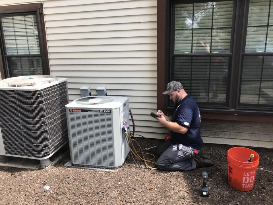 A service technician for Christian Heating and Air Conditioning of Upper Southampton checks out an air-conditioner function.