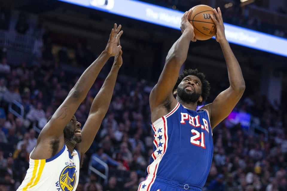 Philadelphia 76ers center Joel Embiid (21) shoots over Golden State Warriors forward Draymond Green (23) during the first half of an NBA basketball game, Tuesday, Jan. 30, 2024, in San Francisco. (AP Photo/D. Ross Cameron)