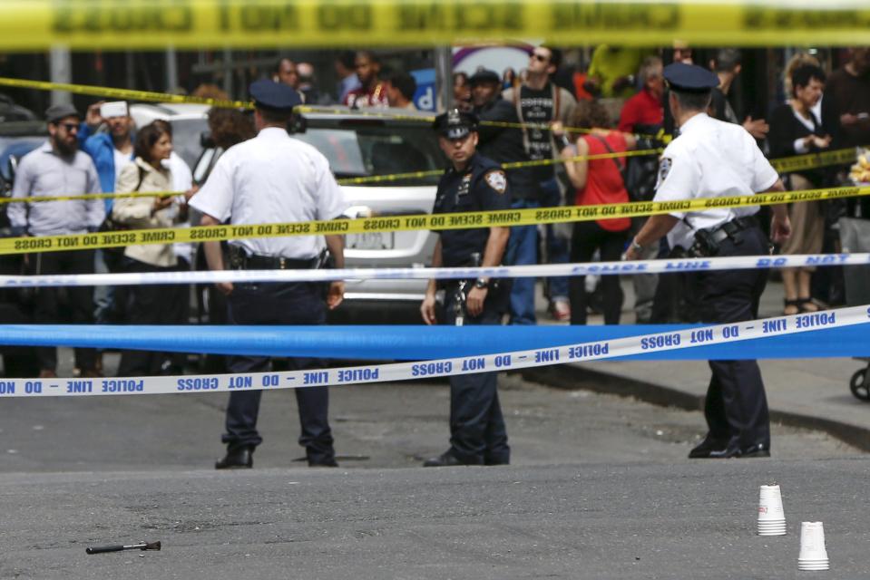 Members of the NYPD police stand near the crime scene at the intersection of 37th street and 8th avenue in midtown Manhattan in New York