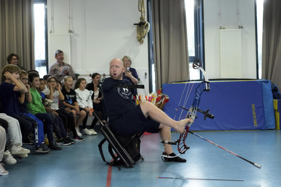 Archer Matt Stutzman of United States reacts during a performance in a Paris school, in Paris, Wednesday, Oct. 4, 2023. Visiting France's capital before Paralympic tickets go on sale next week, Stutzman dropped by a Paris school on Wednesday and wowed its young pupils with his shooting skills. (AP Photo/Thibault Camus)