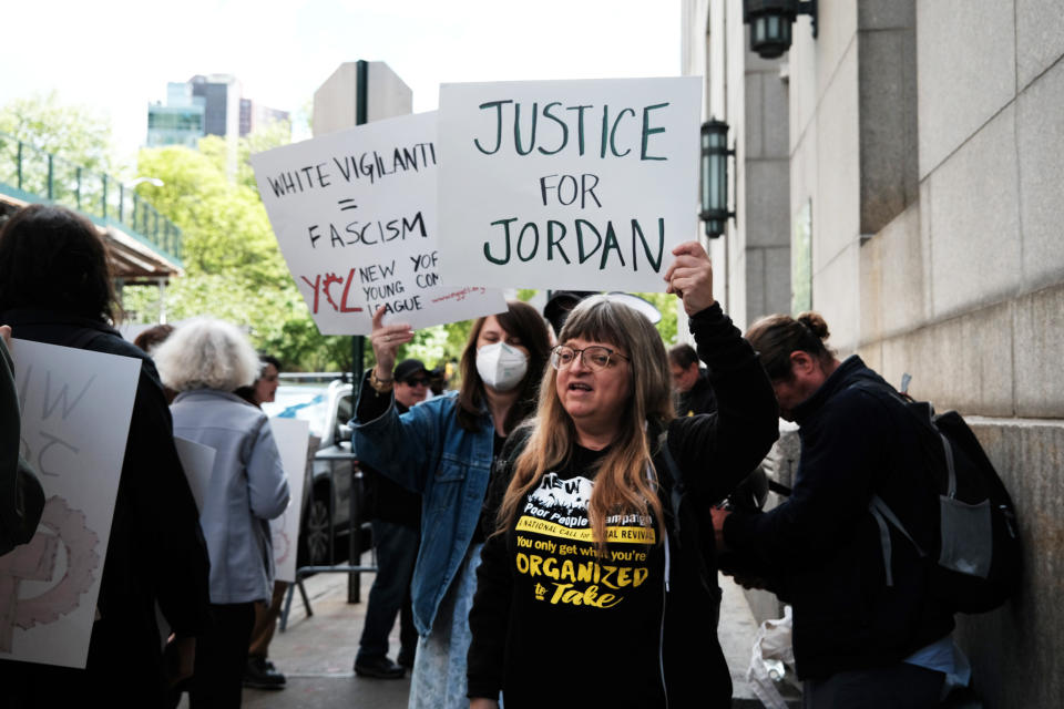 Protesters wave signs as they gather for a 