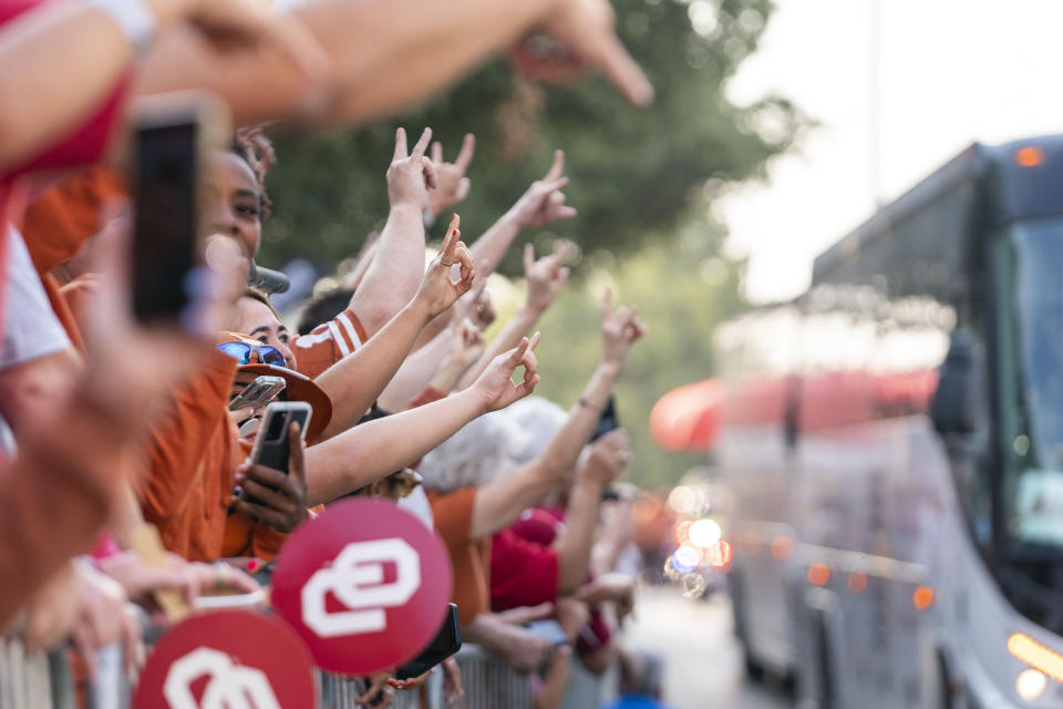 FILE - Texas and Oklahoma fans cheer as the Texas team buses arrive before an NCAA college football game at the Cotton Bowl, Saturday, Oct. 8, 2022, in Dallas. The Big 12 is losing its marquee matchup when the Red River Rivalry is played Saturday for the final time under the league’s umbrella. (AP Photo/Jeffrey McWhorter, File)