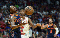 New York Knicks guard Immanuel Quickley (5) reaches for the ball in front of Miami Heat guard Kyle Lowry (7) during the first half of an NBA basketball game, Wednesday, March 22, 2023, in Miami, Fla. (AP Photo/Michael Laughlin)