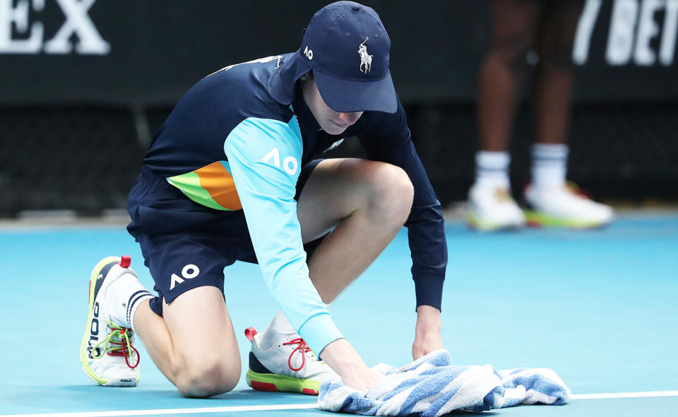 A ball kid, pictured here removing water from the court at the Australian Open.