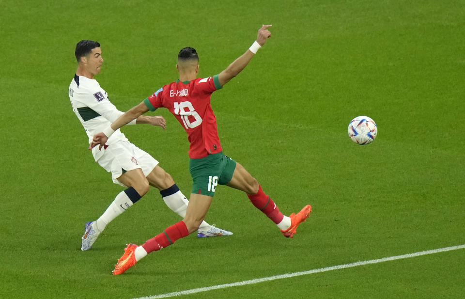 Morocco's Jawad El Yamiq, front tries to block a shot from Portugal's Cristiano Ronaldo during the World Cup quarterfinal soccer match between Morocco and Portugal, at Al Thumama Stadium in Doha, Qatar, Saturday, Dec. 10, 2022. (AP Photo/Luca Bruno)