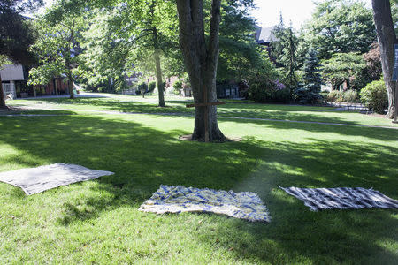 Abandoned blankets lay on a lawn near a wooden cross at Seattle Pacific University after the campus was evacuated due to a shooting in Seattle, Washington June 5, 2014. REUTERS/David Ryder
