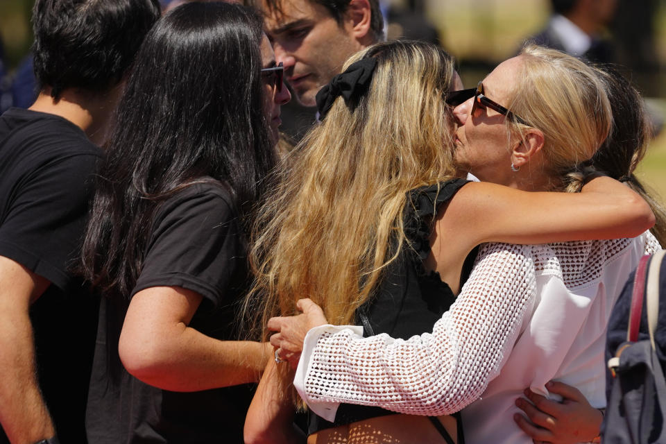 Cecilia Morel, the widow of former Chilean President Sebastian Pinera, right, hugs relatives while receiving the remains of her husband at the airport in Santiago, Chile, Wednesday, Feb. 7, 2024. The two-time former president died on Feb. 6 in a helicopter crash. He was 74. (AP Photo/Esteban Felix)