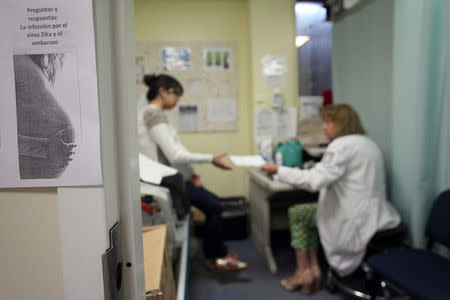 A flyer that reads, "Questions and answers: Zica virus infection during pregnancy" is seen posted outside a doctor's office, at a public hospital in San Juan, Puerto Rico, February 3, 2016. REUTERS/Alvin Baez/File Photo