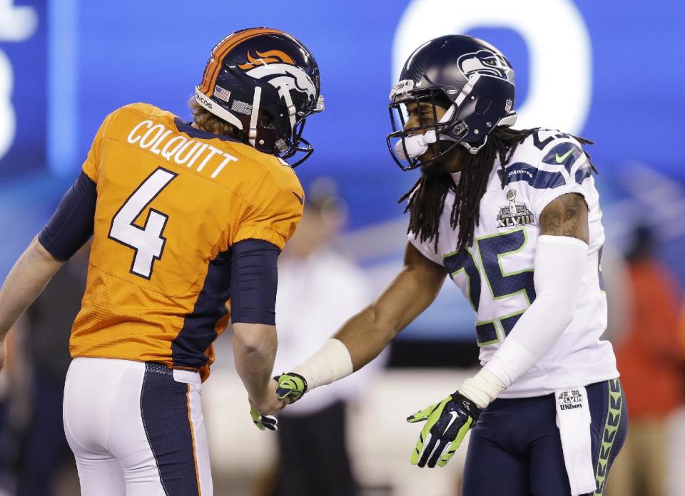 Denver Broncos' Britton Colquitt (4) talks with Seattle Seahawks' Richard Sherman (25) before the NFL Super Bowl XLVIII football game Sunday, Feb. 2, 2014, in East Rutherford, N.J. (AP Photo/Jeff Roberson)