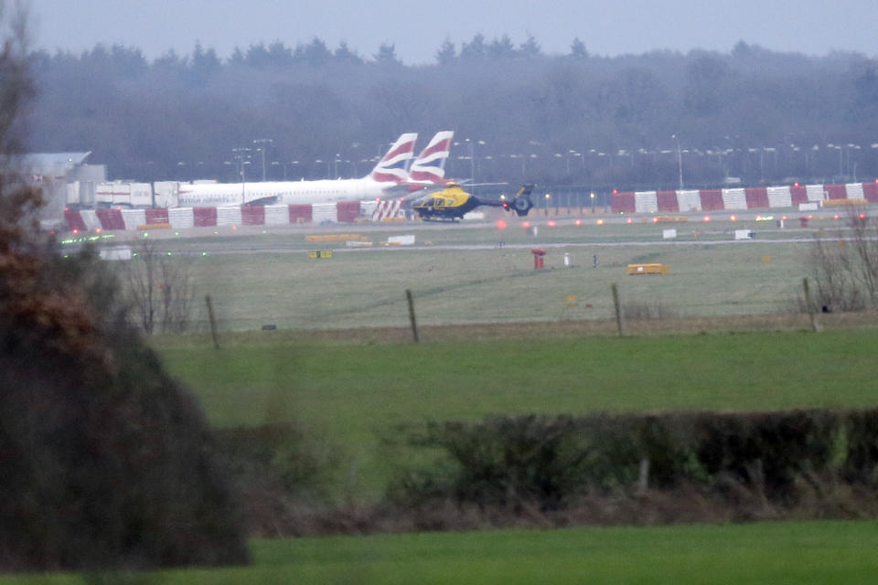 A police helicopter flies over Gatwick Airport as the airport remains closed after drones were spotted over the airfield last night and this morning, in Gatwick, England, Thursday, Dec. 20, 2018. Drones spotted over the runway forced the shutdown of London's Gatwick Airport on Thursday during one of the busiest times of the year, stranding or delaying tens of thousands of Christmas-season travelers and setting off a hunt for the operator of the intruding aircraft. (AP Photo/Tim Ireland)