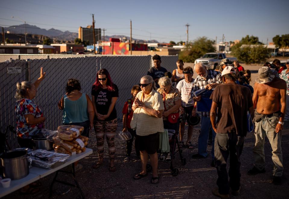 Norma Thornton, left, says a prayer with those assembled to receive a free meal she has prepared in Bullhead City, Ariz., on Tuesday, Oct. 24, 2023. | Spenser Heaps, Deseret News