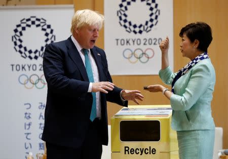 Britain's Foreign Secretary Boris Johnson (L) talks with Tokyo Governor Yuriko Koike before he feeds a smartphone into a box collecting old mobile phones from Tokyo residents, which will be recycled into medals for the 2020 Tokyo Olympics and Paralympics, during their meeting at Tokyo Metropolitan Government buildingin Tokyo, Japan July 21, 2017. REUTERS/Issei Kato