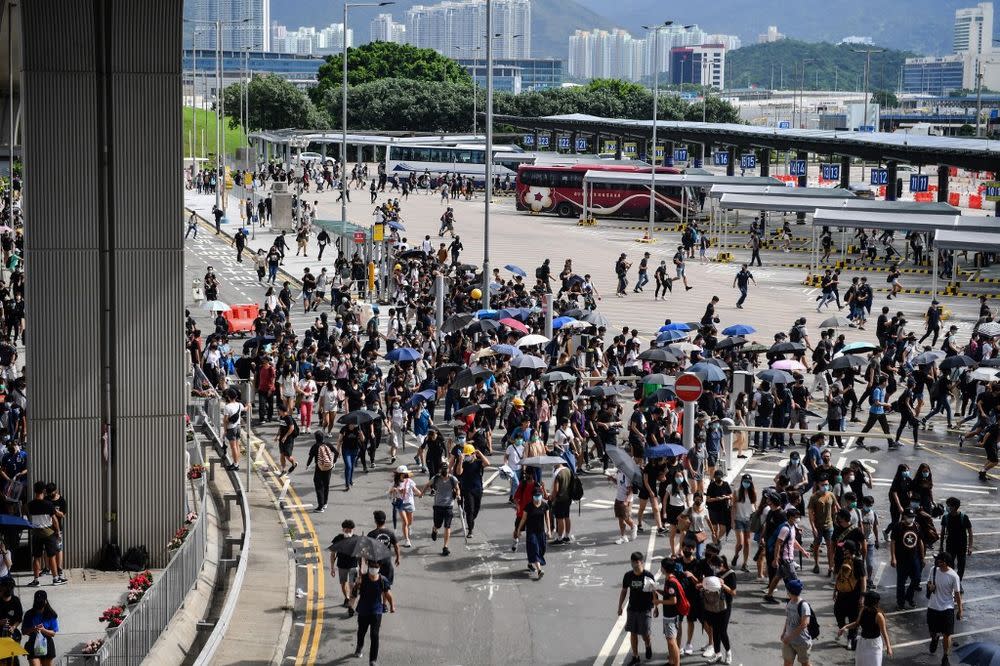 Protesters run from police at the bus terminal at Hong Kong International Airport on September 1, 2019. — AFP pic