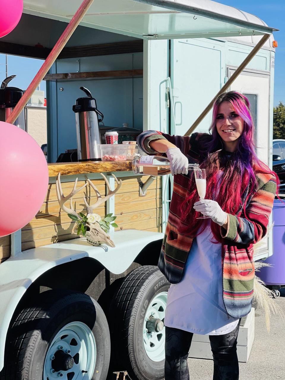 Halley Ehler pours mocktails for guests from the Tipsy Daisy Mobile Bar at the grand opening of Amazing Graze Charcuterie Saturday, Nov. 6, 2021.