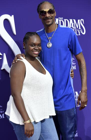 Snoop Dogg, right, wears a blue shirt and blue leather pants and Cori Broadus, left, wears a white blouse and blue jeans