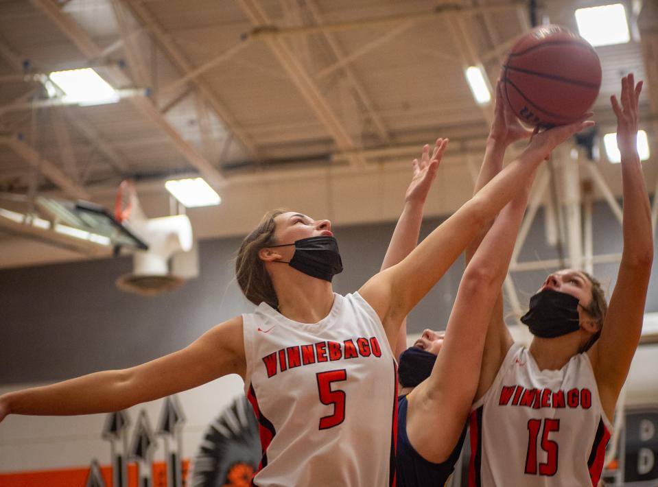 Renee Rittmeyer, No. 5, reaches for a rebound during the first quarter of their game against Freeport Aquin on Thursday, Dec. 16, 2021, in Winnebago.