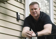 In this Tuesday, July 16, 2019, photo, Ernie Field poses for a photograph next to a Ring doorbell camera at his home in Wolcott, Conn. Field won a free Ring camera and said he had to register for the app to qualify for the raffle. Now he gets alerts on his phone when a car drives by and a 30-second video when his daughter gets home from school. (AP Photo/Jessica Hill)