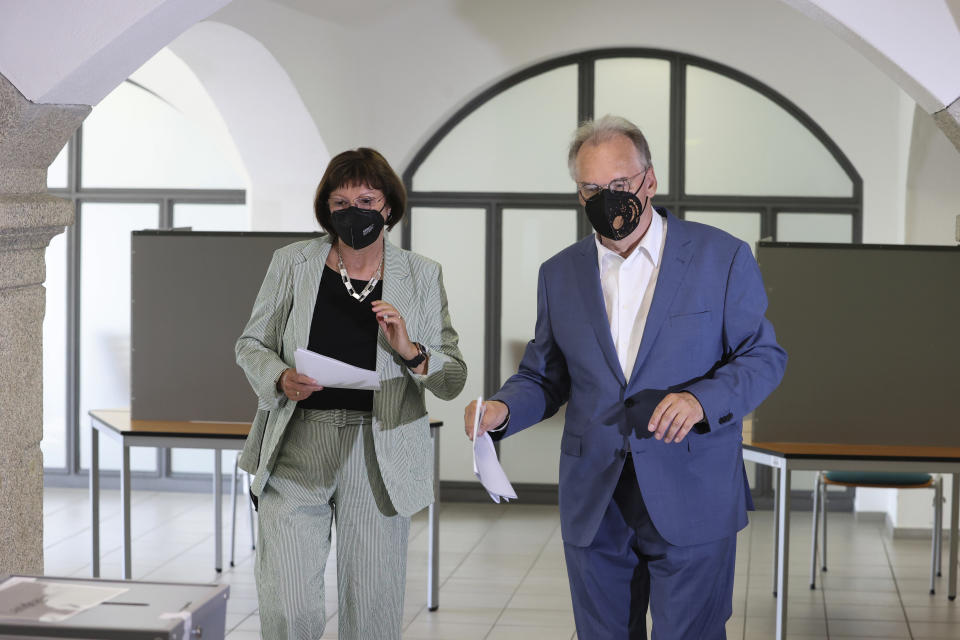 The governor of Saxony- Anhalt Reiner Haseloff, right, of Chancellor Angela Merkel's Christian Democratic Union party, CDU, and his wife Gabriele Haseloff, cast their vote for the state election of Saxony- Anhalt at a polling station in Wittenberg, Germany, Sunday, June 6, 2021. The election for the new state parliament in Saxony-Anhalt is the last state election before the national election in September 2021. (Robert Michael/dpa via AP)