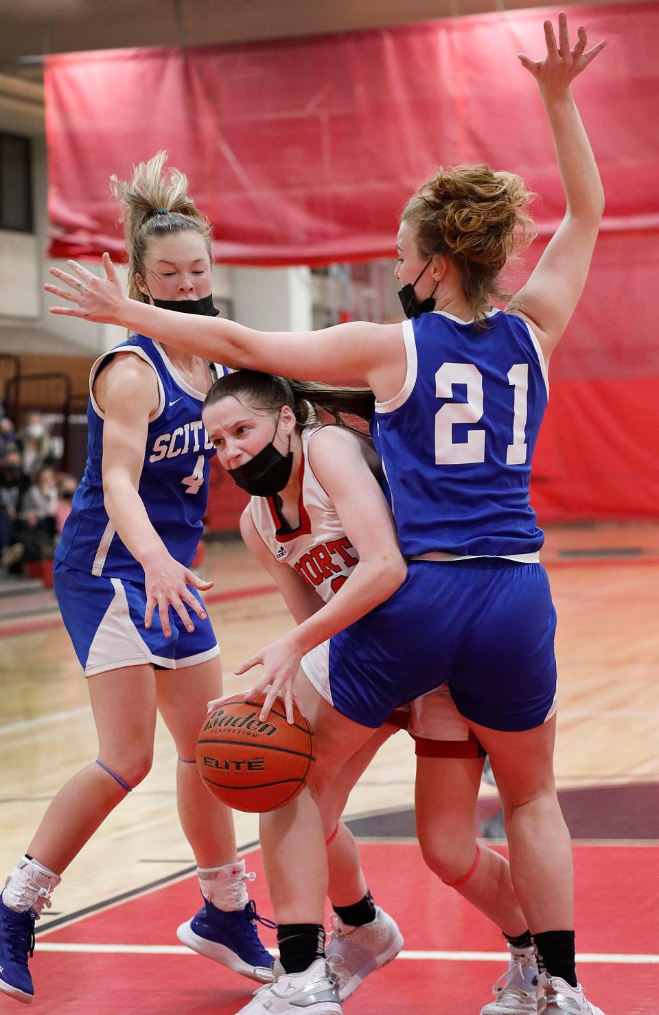 North Quincy captain Orlagh Gormley tries to squeeze between Scituate's Grace McNamara and Jordan Gardener to get off a shot during a game on Friday, Dec. 17, 2021.