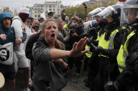 Riot police face protesters who took part in a 'We Do Not Consent' rally at Trafalgar Square, organised by Stop New Normal, to protest against coronavirus restrictions, in London, Saturday, Sept. 26, 2020. (AP Photo/Frank Augstein)