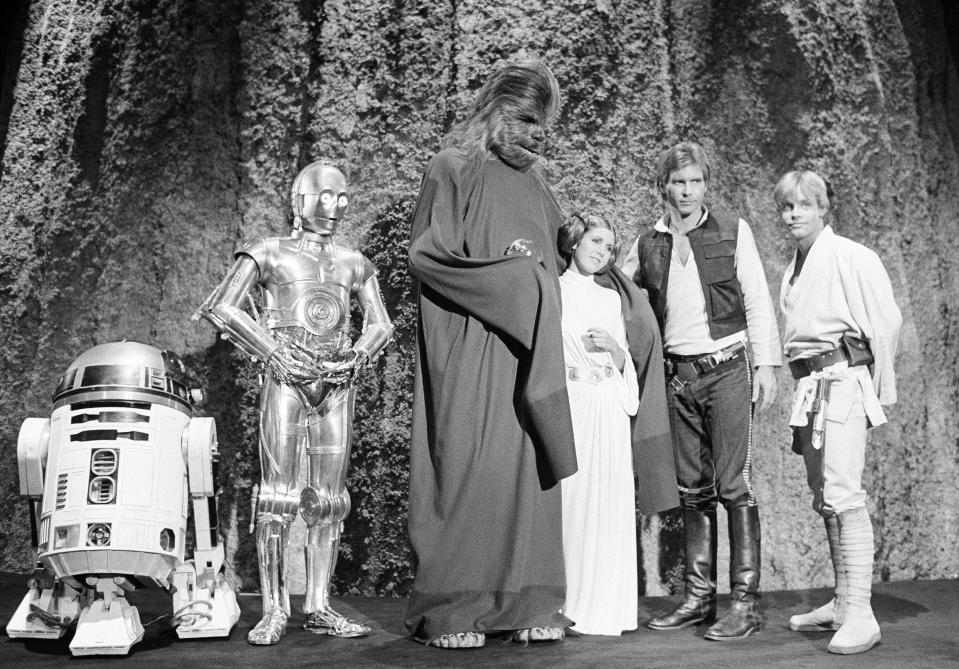 Harrison Ford, as Han Solo of “Star Wars” with Carrie Fisher in the filming of the CBS-TV special “The Star Wars Holiday” Nov. 13, 1978. Ford says he leaves the singing in the special to Carrie, who is the daughter of Eddie Fisher and Debbie Reynolds. The film will also feature many special effects not seen on the original movie. (AP Photo/George Brich)