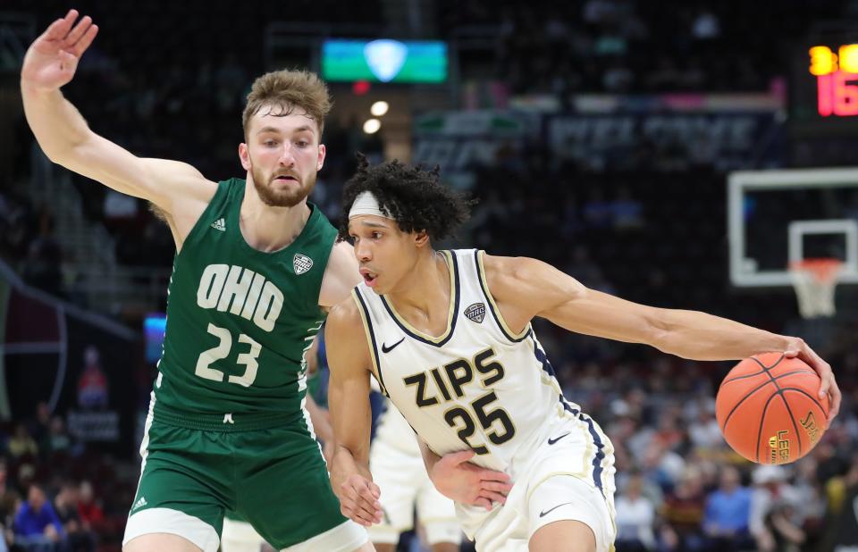 Akron Zips forward Enrique Freeman (25) drives against Ohio forward AJ Clayton during the second half of an NCAA college basketball game in the semifinals of the Mid-American Conference Tournament at Rocket Mortgage FieldHouse, Friday, March 15, 2024, in Cleveland, Ohio.