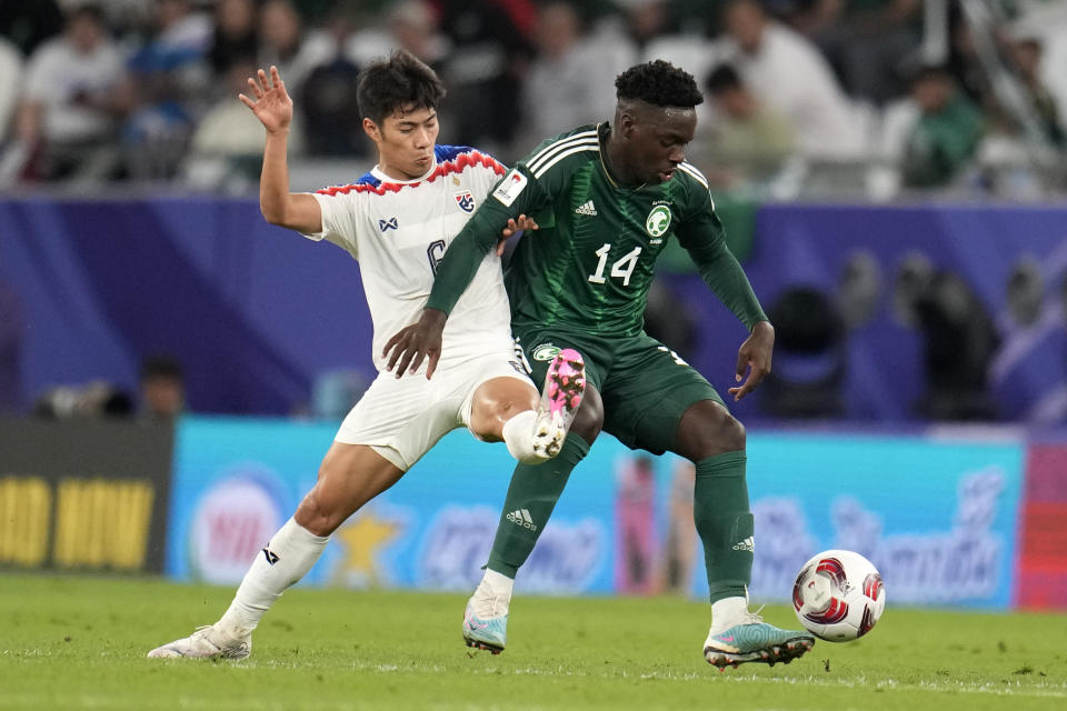 Saudi Arabia's Abbas Alhassan, right, and Thailand's Sarach Yooyen fight for the ball during the Asian Cup Group F soccer match between Saudi Arabia and Thailand at Education City Stadium, in Al Rayyan, Qatar, Thursday, Jan. 25, 2024. (AP Photo/Aijaz Rahi)