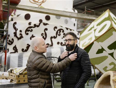 Aubrey Loots (L) adjusts Danny Leclair's jacket as they prepare for a television interview in front of the AIDS Healthcare Foundation (AHF) Tournament of Roses Parade parade float, at Fiesta Parade Floats in Irwindale, California December 30, 2013. REUTERS/Kevork Djansezian