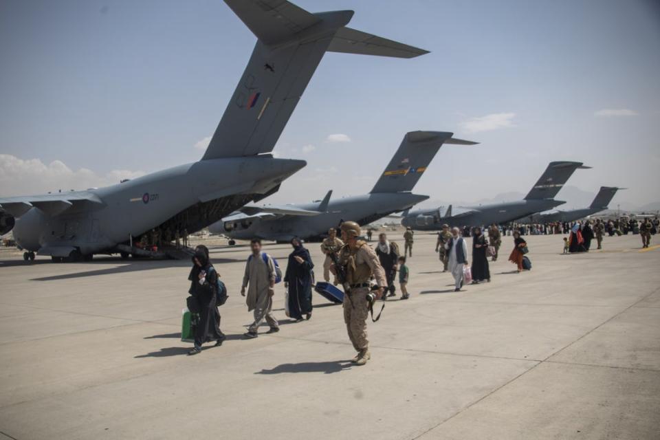 Members of the UK Armed Forces leading evacuees past ZZ171 (nearest camera), an Royal Air Force Boeing C-17A Globemaster III, at Kabul airport (LPhot Ben Shread/MoD/PA) (PA Media)