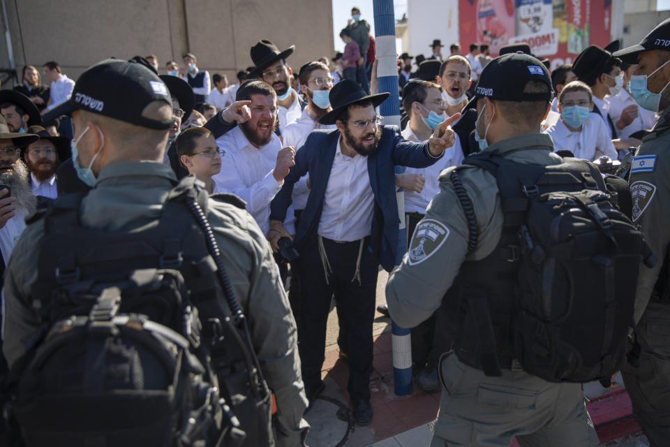 Image: Ultra-Orthodox Jews confront an Israeli officer over lockdown restrictions  (Oded Balilty / AP)